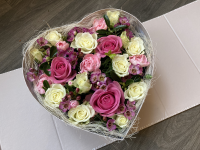 Grey Heart Surprise - This beautifully presented Grey Heart shaped box arrives closed and then open up to reveal a lovely arrangement of fresh flowers. The sides then fold back to angle the box to show of the beautiful arrangement. The standard includes Roses and other seasonal flowers.