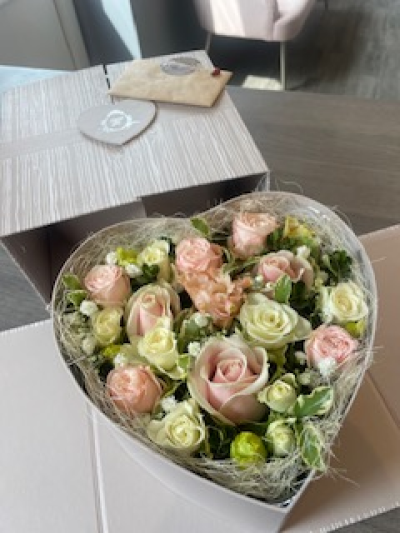 Grey Heart Surprise - This beautifully presented Grey Heart shaped box arrives closed and then open up to reveal a lovely arrangement of fresh flowers. The sides then fold back to angle the box to show of the beautiful arrangement. The standard includes Roses and other seasonal flowers.