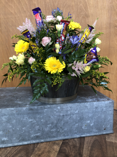 Two of the Best Things - This lovely arrangement is arranged in a basket (colour may vary), with seasonal flowers and has Chocolate Bars added in ! Win Win