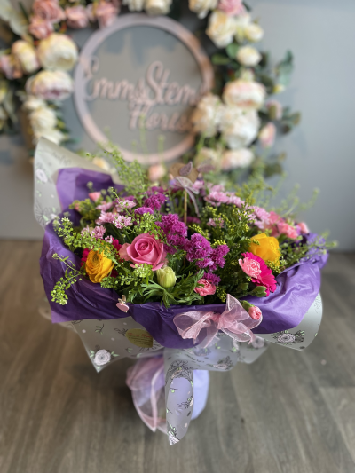 Rise and shine Mum - Fresh beautiful flowers arranged in an aquarium packed bouquet in shades of pink, purple & yellow.