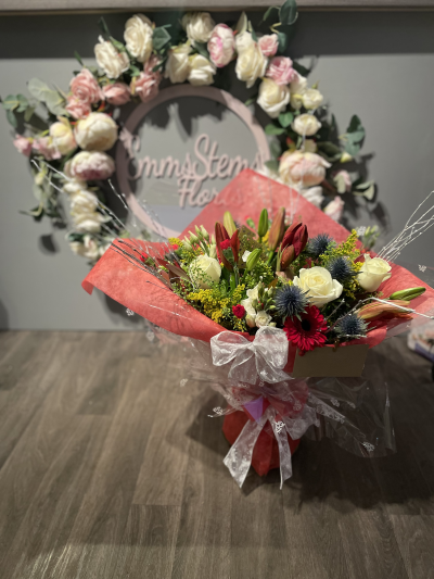 Christmas Cheer - Seasonal flowers in red and white arranged in a aqua packed bouquet.